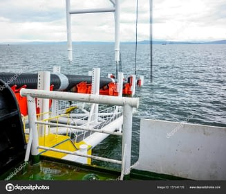 Laying of pipes with pipe-laying barge crane near the shore. Descent of the pipeline to a bottom exhausting with the pipelaying barge. Installation of the underwater gas pipeline
